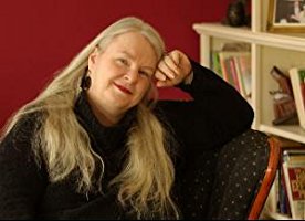 Author Susan Tuttle seated in her library and smiling